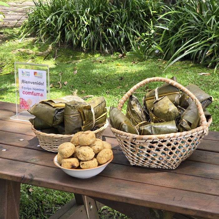 Mesa de comida al aire libre. Tamales antioqueños tradicionales en canastas de mimbre. Explora La Ceja con Viajes Comfama